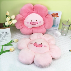 Détail de coussins en peluche en forme de fleur rose avec visages souriants brodés