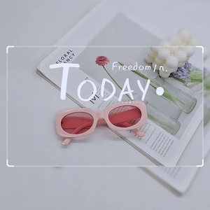 Pink retro rectangular sunglasses on an art magazine with a bubble candle decor