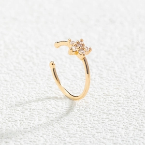 Detailed view of gold flower-shaped non-pierced nose clip with white zircon stones