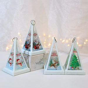 Detailed view of four pyramid-shaped Christmas lanterns with festive Santa and reindeer prints