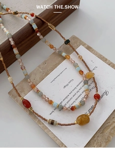 Detailed close-up of beaded necklace featuring red agate and colorful natural stones