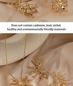Detail of gold sunburst necklace and earrings set on soft champagne silk fabric
