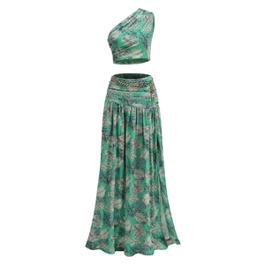 Detail of tropical leaf print two-piece set featuring off-shoulder top and metal chain belt