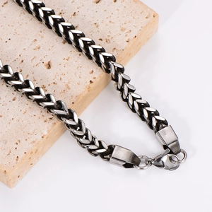 Silver cuban wheat chain necklace for men with lobster clasp on stone pedestal