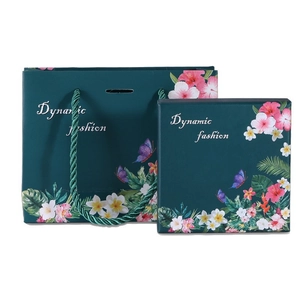 Detail of dark green gift box and paper bag with tropical floral and butterfly patterns