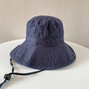 Détail d'un chapeau de soleil en nylon bleu foncé avec œillets et cordon ajustable