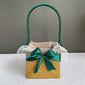 Detail of seagrass basket with green ribbon handle and white star tulle lining