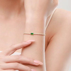 Elegant gold bracelet with rectangular green emerald zircon on model wrist shot