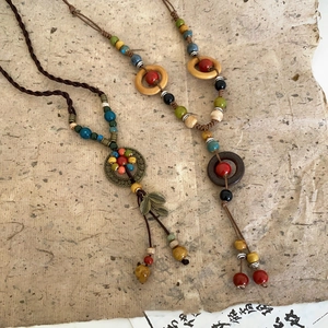 Detail of vintage ethnic necklace with colorful ceramic beads and bronze leaf pendant