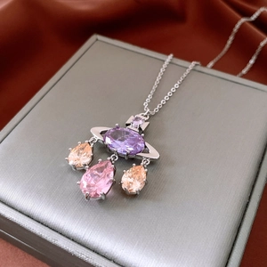 Macro shot of silver-tone orb pendant necklace with purple and pink zircon gemstones