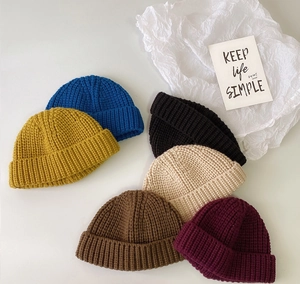 Plano cenital de gorros de punto grueso en seis colores con detalles de textura premium