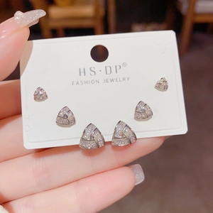 Three pairs of geometric triangle stud earrings with sparkling zircon on a display card