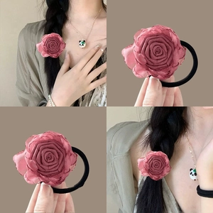 Detail of a dark pink fabric rose hair tie with elastic band for vintage braided hairstyles