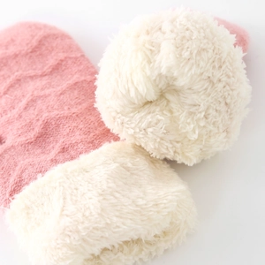 Gros plan détaillé de moufles en tricot rose pour bébé avec doublure en polaire blanche