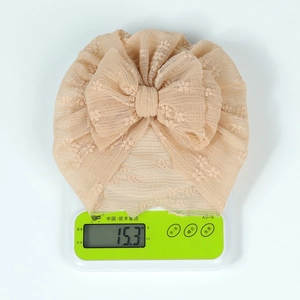 Close-up of lightweight lace baby turban with oversized bow showing 15.3g weight