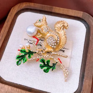 Broche écureuil vintage avec strass et perle blanche sur une branche dorée