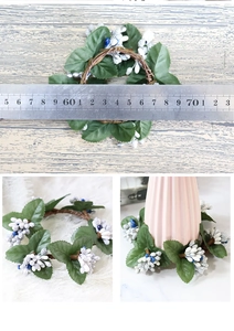 Macro detail of artificial green leaves and white berries on a decorative candle ring