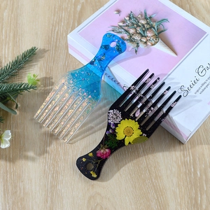 Detailed macro view of resin hair combs featuring gold foil and dried floral inserts