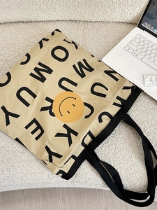 Minimalist smiley canvas tote bag with black handles and spacious capacity for daily use