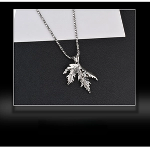 Gros plan sur le collier pendentif feuille d'érable en argent avec nervures et textures détaillées