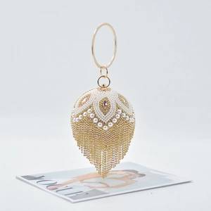 Macro detail of sphere evening bag featuring white pearls, gold rhinestones and long tassels