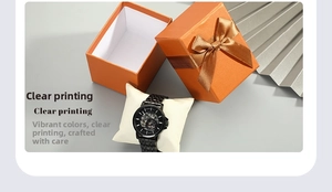 Detail of all-black steel mechanical watch with hollow dial in orange ribbon gift box