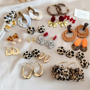 Collection of leopard print and geometric earrings on elegant champagne satin fabric