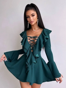 Détail de la robe vert foncé à col en V avec volants aux manches évasées et laçage chic