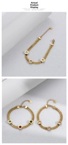 Detail of gold woven chain bracelet featuring round pendants with colored zircons and Roman numerals