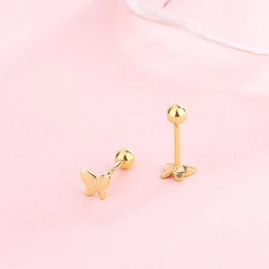 Macro shot of S925 silver butterfly screw earrings in gold finish on pink satin fabric