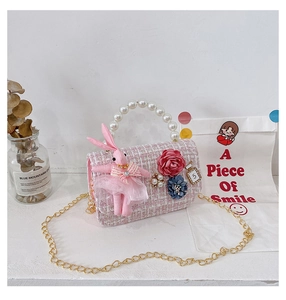 Detailed view of pink tweed kids bag with pearl handle and cute bunny pendant