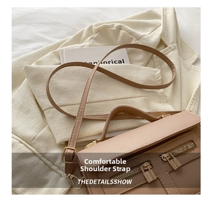 Détail d'un sac à main en cuir marron avec zips dorés et bandoulière réglable chic