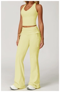 Detail of yellow yoga set featuring high waist flare pants with drawstring side rushing