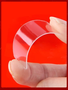 Macro shot showing high flexibility of transparent non-marking double-sided tape on red background