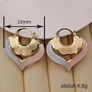 Three-tone heart hoop earrings in gold, silver, and rose gold with wavy engraved texture