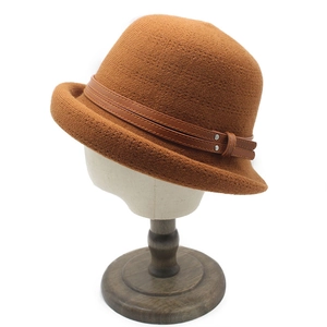 Brown knit cloche hat with a dark leather decorative band on a white mannequin head