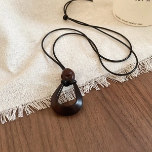 Macro view of water drop shaped resin pendant on a wax cord vintage necklace