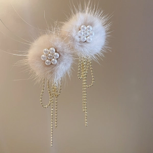 Detailed macro view of plush apricot flower earrings with pearl accents and gold tassels