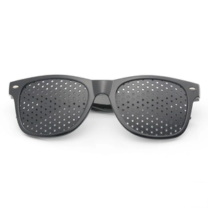 Macro detail of black matte pinhole glasses featuring a dense array of fine corrective holes