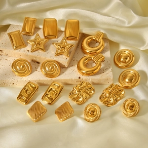 Detail of assorted 18K gold plated stainless steel earrings on silk and stone base