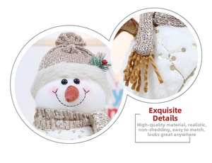 Close-up of knit hat, carrot nose and sequined scarf detail on a plush snowman doll
