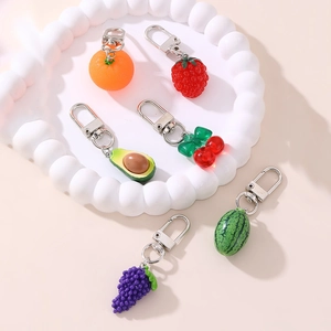 Detailed close-up of six cute resin fruit keychains including strawberry and cherry models