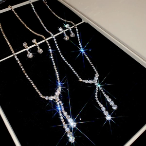 Close-up of gold and silver jewelry sets with sparkling round pendants on black velvet