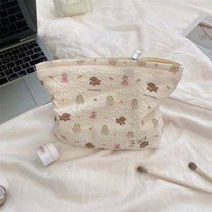 Detail of embossed cream makeup bag with cute animal patterns on a soft white background