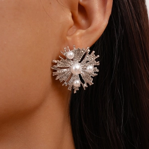 Macro view of silver coral textured earrings featuring four white faux pearls on model