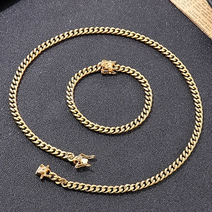 Detailed close-up of a golden Cuban chain necklace and bracelet set on black texture