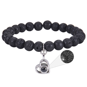 Close-up of black lava stone beads and silver heart pendant with I Love You projection