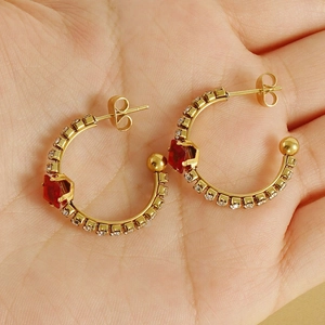 Detail view of 18K gold-plated earrings with red square gemstone and paved crystals