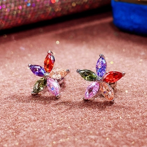 Macro shot of colorful flower star earrings with marquise-cut gems on pink sequins