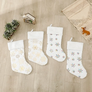 Chaussettes de Noël en peluche avec sequins et flocons sur fond de parquet en bois chaleureux
